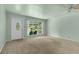 Inviting living room features neutral carpet, large windows, and a view of the outdoor seating area at 3373 Olson Rd, Spring Hill, FL 34607