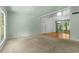 Bright living room with carpeted floors, a ceiling fan, and ample natural light from a large window and glass doors at 3373 Olson Rd, Spring Hill, FL 34607