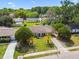 Aerial view of home with manicured lawn and mature palm trees in the front yard at 3628 Dellefield St, New Port Richey, FL 34655