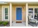 Close-up of front door with a charming blue color, decorative window, and welcoming mat at 3628 Dellefield St, New Port Richey, FL 34655