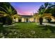 Charming single-story home with lush lawn, palm trees, and inviting curb appeal at dusk at 3628 Dellefield St, New Port Richey, FL 34655