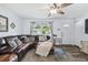 Bright living room features a large sectional, stylish rug, and view of front yard at 3628 Dellefield St, New Port Richey, FL 34655