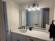 Bathroom with white vanity, modern black hardware and light fixture, with framed mirror at 3640 41St S Ln # F, St Petersburg, FL 33711