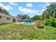Backyard featuring a pool, fire pit, shed, and green grass at 3641 Coppertree Cir, Brandon, FL 33511