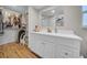 Bright bathroom features a walk-in closet and a vanity with white cabinets and a large mirror at 3641 Coppertree Cir, Brandon, FL 33511