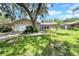 Charming single-story home with a stone facade, lush green lawn, mature tree, and a two-car garage at 3641 Coppertree Cir, Brandon, FL 33511