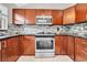 A kitchen with wooden cabinets, stainless steel appliances, granite countertops, and a decorative backsplash at 3641 Coppertree Cir, Brandon, FL 33511