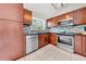 Bright kitchen featuring wooden cabinets, stainless steel appliances, tile flooring and backsplash, and a window at 3641 Coppertree Cir, Brandon, FL 33511
