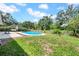 Inviting in-ground pool surrounded by lush green landscaping, perfect for relaxation at 3641 Coppertree Cir, Brandon, FL 33511