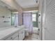 Cozy bathroom with floral wallpaper, a vanity, and a bathtub with a shower curtain at 3849 Hollow Oak Pl, Land O Lakes, FL 34639