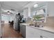 Charming kitchen with a stainless steel dishwasher and sink beneath a window, next to an open-concept living area at 3849 Hollow Oak Pl, Land O Lakes, FL 34639