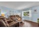 Cozy living room with hardwood floors, comfortable leather seating, and ample natural light at 3849 Hollow Oak Pl, Land O Lakes, FL 34639