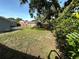 Backyard featuring a grassy yard, wood fence, mature trees, and lush shrubbery at 3980 55Th N Ave, St Petersburg, FL 33714