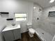 Bathroom featuring updated vanity with gray cabinets, a new toilet, and a tiled shower at 3980 55Th N Ave, St Petersburg, FL 33714