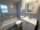 Bathroom featuring blue tiling throughout, vanity with storage, and updated fixtures at 3980 55Th N Ave, St Petersburg, FL 33714