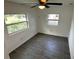 Bedroom showcasing wood floors, ceiling fan, and bright windows with views of the outdoors at 3980 55Th N Ave, St Petersburg, FL 33714
