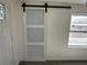 Hallway featuring modern white barn door, gray wood-look tile flooring and a window view at 3980 55Th N Ave, St Petersburg, FL 33714
