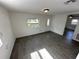 Inviting living room featuring gray wood-look tile, white walls, a ceiling light, and a view into another room at 3980 55Th N Ave, St Petersburg, FL 33714