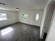 Bright living room featuring gray wood-look tile floors, a modern ceiling light, and a white front door with glass at 3980 55Th N Ave, St Petersburg, FL 33714