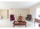 A well lit living room featuring neutral walls, two chairs, a vintage table, and white tile flooring at 4030 Cortez Dr # C, Tampa, FL 33614