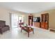 A spacious living room with tile flooring, stylish wooden furniture, and sliding doors leading to a balcony at 4030 Cortez Dr # C, Tampa, FL 33614