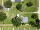 Aerial view of the property showing the house, detached garage, storage shed, and surrounding greenery at 4030 Moores Lake Rd, Dover, FL 33527