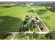 Expansive aerial view of a property with mature trees and bordered by lush green agricultural fields at 4030 Moores Lake Rd, Dover, FL 33527