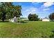 View of the backyard with a covered carport and detached garage, showcasing the property's ample parking and storage at 4030 Moores Lake Rd, Dover, FL 33527