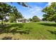 View of home with lush green lawn, established trees, and partially fenced yard offering privacy at 4030 Moores Lake Rd, Dover, FL 33527