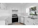 Modern kitchen equipped with stainless steel appliances, white cabinetry, and bright natural light at 4030 Moores Lake Rd, Dover, FL 33527