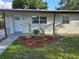 Inviting front entrance with landscaped garden, modern white door, and charming details at 4104 W Wisconsin Ave, Tampa, FL 33616