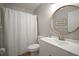Bright bathroom featuring a modern vanity, toilet, shower with curtain, and round mirror at 4325 Aegean Dr # 250B, Tampa, FL 33611