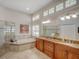 Luxurious bathroom featuring a soaking tub, dual vanity, and ample natural light from clerestory windows at 4335 Clairidge Way, Palm Harbor, FL 34685