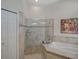 Elegant bathroom with a glass-enclosed shower, soaking tub, and neutral tile finishes at 4335 Clairidge Way, Palm Harbor, FL 34685