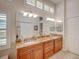 Bathroom with a double sink vanity, granite countertops, and a large mirror at 4335 Clairidge Way, Palm Harbor, FL 34685