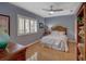 Bedroom featuring hardwood floors, plantation shutters, ceiling fan, and queen bed at 4335 Clairidge Way, Palm Harbor, FL 34685
