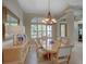 Elegant dining room features a wooden table, chandelier, and a bright window with plantation shutters at 4335 Clairidge Way, Palm Harbor, FL 34685