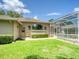 View of the home's exterior featuring the screened-in pool and well-kept landscaping at 4335 Clairidge Way, Palm Harbor, FL 34685