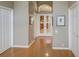 Hallway with hardwood floors leading into a kitchen area with french doors at 4335 Clairidge Way, Palm Harbor, FL 34685