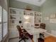 Stylish office boasts built-in shelves, hardwood floors, and a large desk with comfortable chairs at 4335 Clairidge Way, Palm Harbor, FL 34685