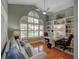 Bright office featuring hardwood floors, vaulted ceiling, built-in bookshelves, and a large arched window at 4335 Clairidge Way, Palm Harbor, FL 34685