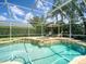 Screened-in pool area with in-ground pool, hot tub, and lounge chairs at 4335 Clairidge Way, Palm Harbor, FL 34685