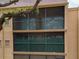 Tan condo building with screened balcony and green foliage. Balcony has metal safety railing with neutral interior at 4411 Shady Terrace Ln # 213, Tampa, FL 33613