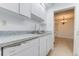 Well-lit kitchen with white cabinets and appliances offering a practical and efficient cooking area at 4411 Shady Terrace Ln # 213, Tampa, FL 33613