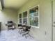 The tiled outdoor balcony features a grill and outdoor seating with views through the windows to trees and sky at 4567 Tuscan Loon Dr, Tampa, FL 33619