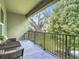 The tiled balcony offers a table and chairs, rod iron railing, and views overlooking a canopy of green trees at 4567 Tuscan Loon Dr, Tampa, FL 33619