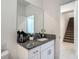 Bathroom vanity with granite counters, white cabinets, and a large mirror at 4567 Tuscan Loon Dr, Tampa, FL 33619