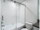 Bathroom featuring toilet, and shower with glass doors and white subway tile surround at 4567 Tuscan Loon Dr, Tampa, FL 33619