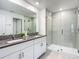 Modern bathroom featuring dual vanity, granite countertops, and a glass-enclosed shower for a spa-like experience at 4567 Tuscan Loon Dr, Tampa, FL 33619