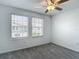 Bright bedroom featuring neutral carpet, fan, and two large windows with blinds at 4567 Tuscan Loon Dr, Tampa, FL 33619